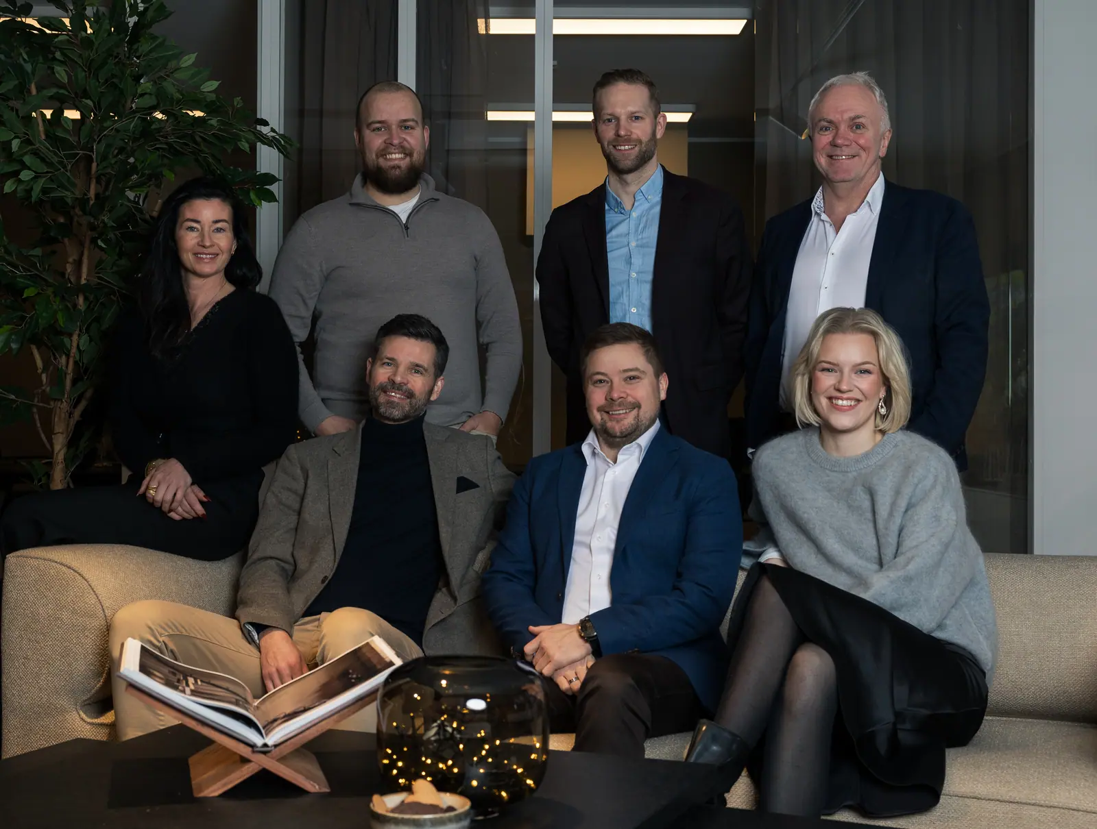 The agents at Hjem Eiendomsmegling gathered on the sofa at the office